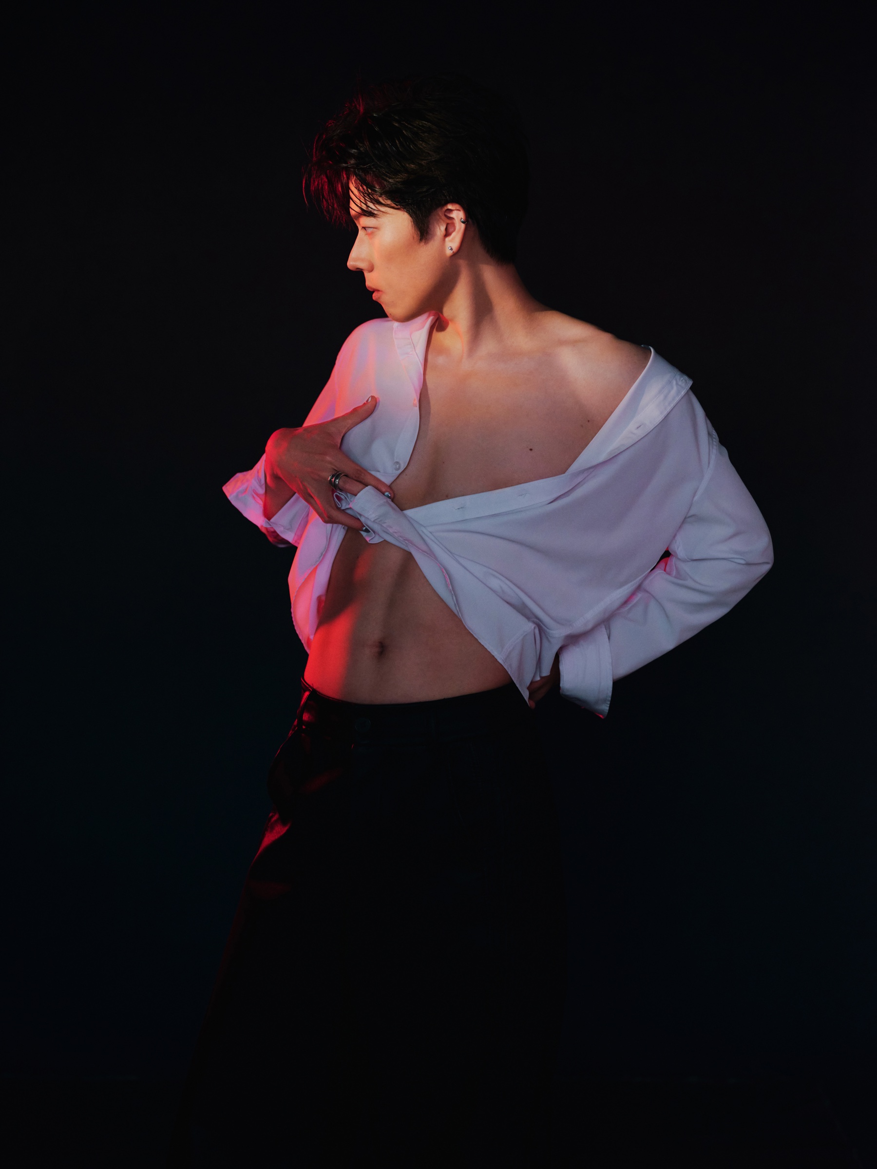 A post-workout portrait with red side lighting, showing the visible result of training